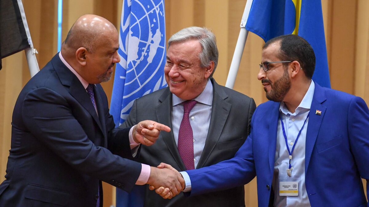 Yemeni Foreign Minister Khaled Yamani, left, and rebel negotiator Mohammed Abdelsalam shake hands Thursday under the eyes of U.N. Secretary-General Antonio Guterres in Rimbo, Sweden.