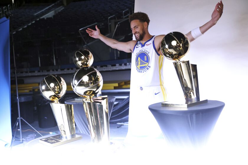 Golden State Warriors' Klay Thompson poses with four Larry O'Brien trophies during Media Day at Chase Center in San Francisco, Sunday, Sept. 25, 2022. (Scott Strazzante/San Francisco Chronicle via AP)