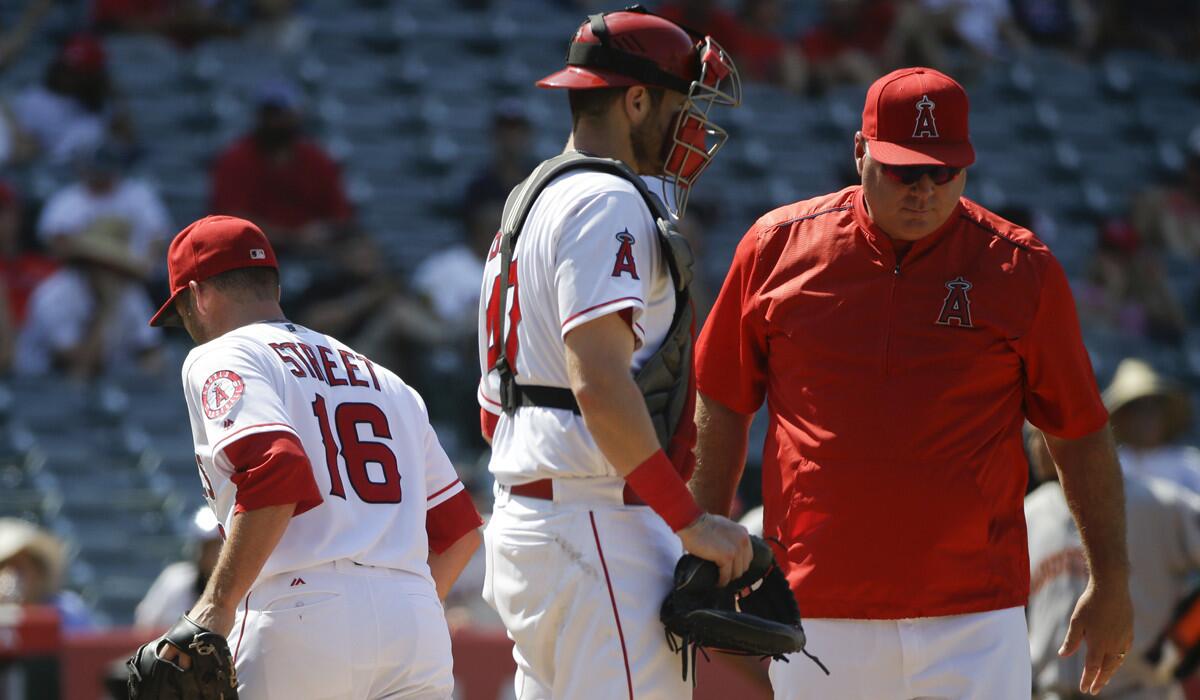 Angels relief pitcher Huston Street, left, leaves the mound after he was pulled by Manager Mike Scioscia, right, during the ninth inning against the Houston Astros on Wednesday.