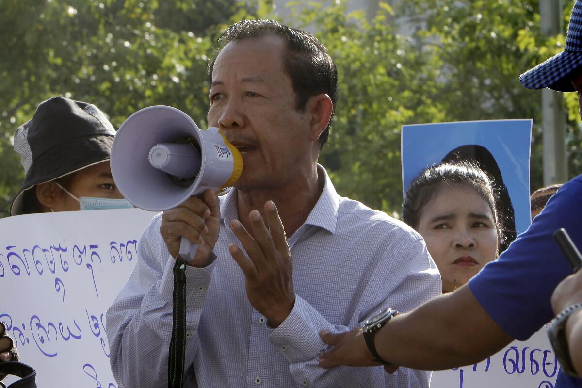 FILE - In this July 29, 2020, file photo, Rong Chhun, president of the Cambodian Confederation of Unions, uses a megaphone during a protest near the prime minister's residence in Phnom Penh, Cambodia. Rong Chhun was sentenced Wednesday, Aug. 18, 2021 to two years in prison for inciting social unrest with sensitive comments about the country's border. (AP Photo/Heng Sinith, File)