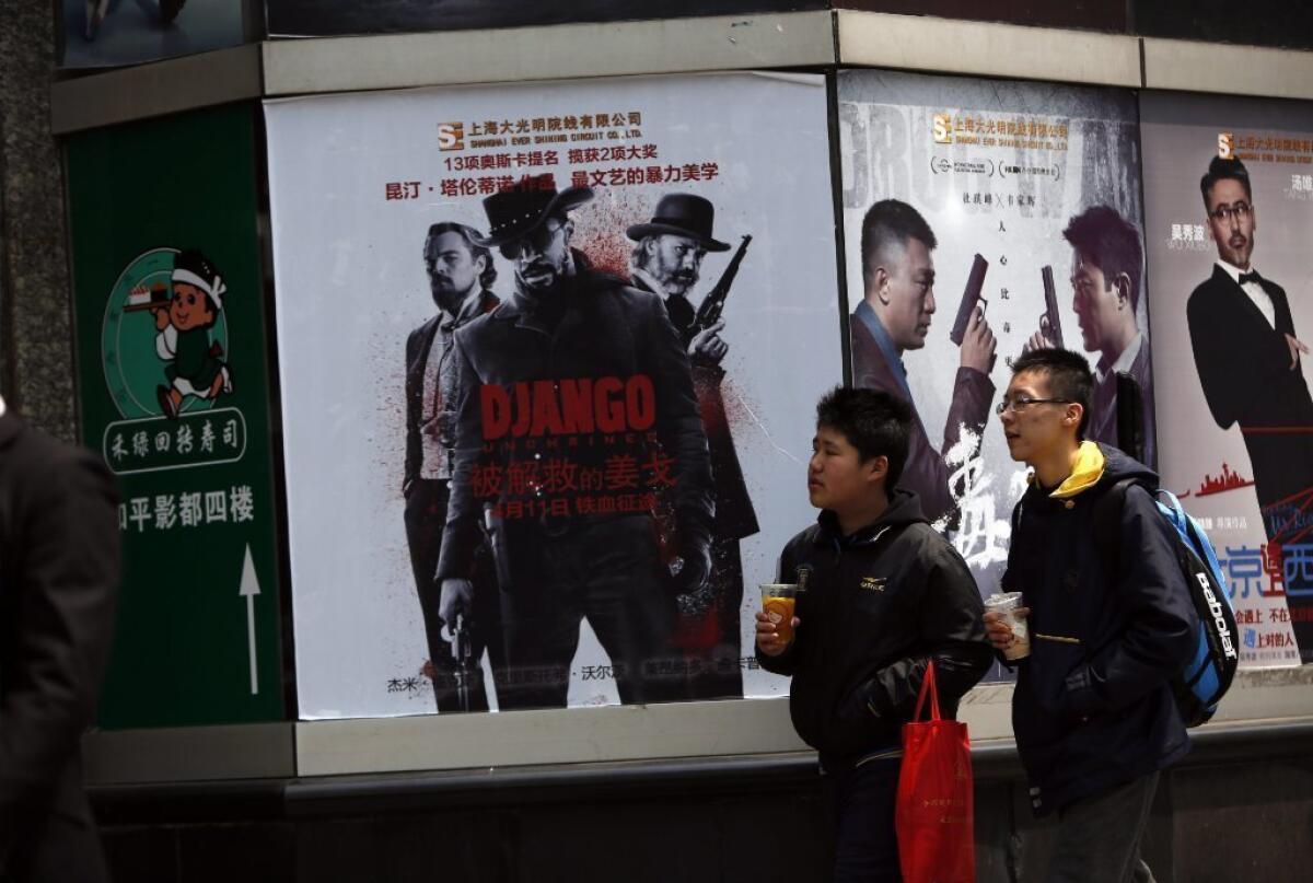 Chinese students walk past a movie poster of "'Django Unchained" in Shanghai, China. After mysteriously vanishing from Chinese theaters two weeks ago, the Quentin Tarantino film will soon return.
