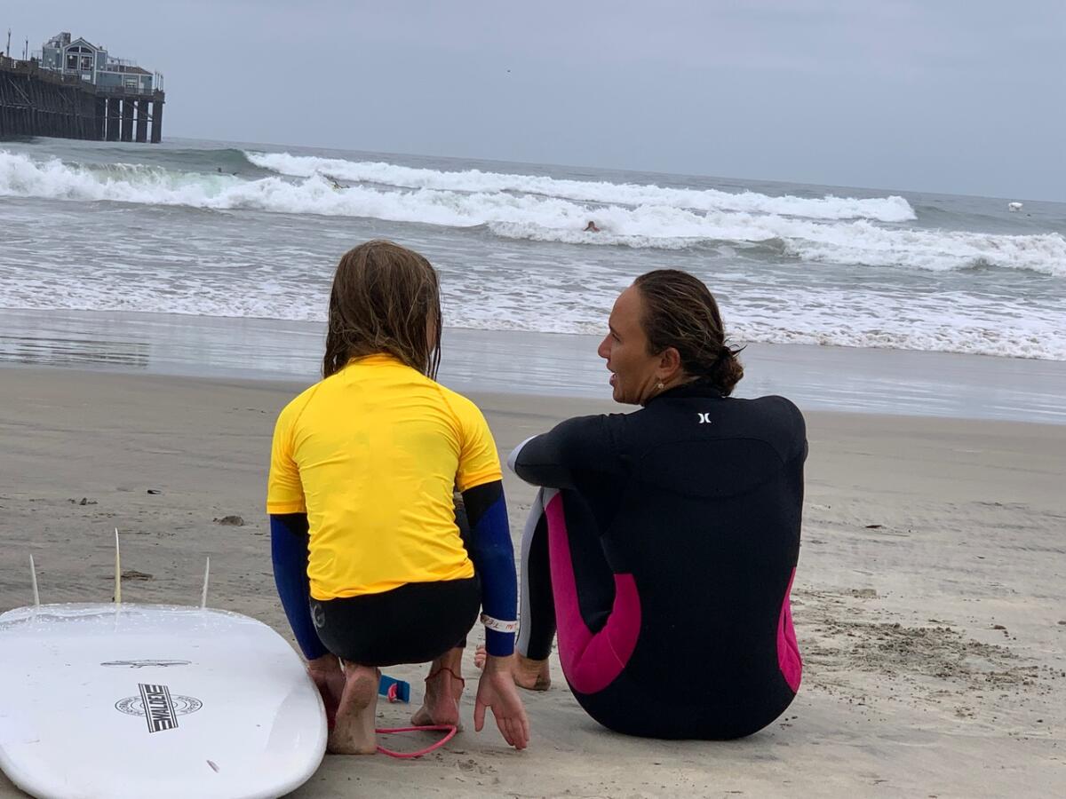 Nervous about trying rough waves, Catalina McDonnell, 10, of La Jolla gets advice from pro surfer Carissa Moore.