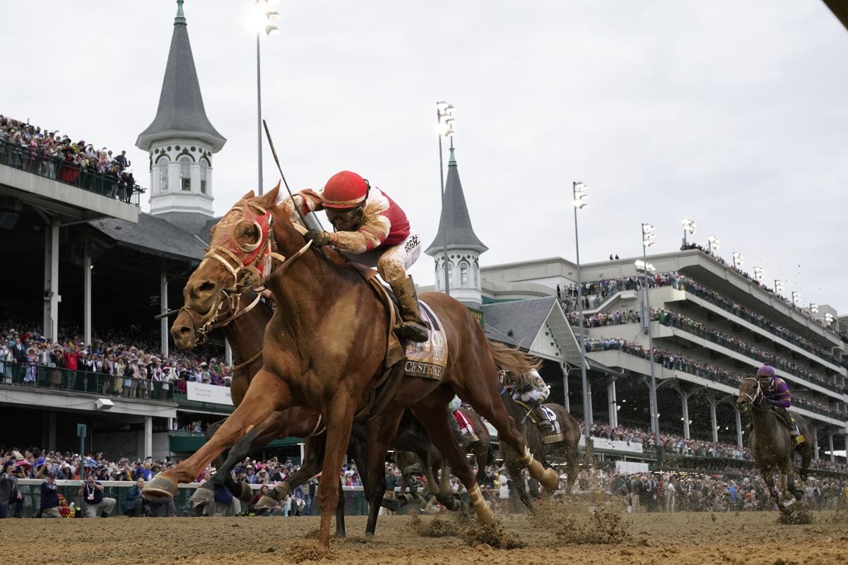 Rich Strike, with jockey Sonny Leon aboard, crosses the finish line to win the 148th running of the Kentucky Derby.