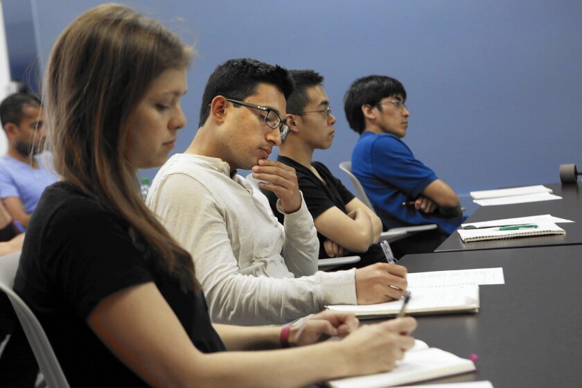 From left, Kate Fehlhaber, Oscar Campos, Calvin Ho, and Eric Yean Lee take notes during UCLA Grad Slam Workshop.