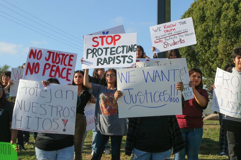 Vista, CA - September 14_Protesters hold signs along Bobier Drive in front of Vista High School. They are protesting in support of a Latino student with autism who was allegedly assaulted by football players. (Charlie Neuman / For The San Diego Union-Tribune)