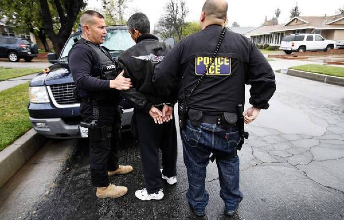 David A. Martin of ICE, left, talks to a detainee during an arrest in Chatsworth. The Trust Act would prohibit local authorities from complying with federal detention requests except when a suspect has been charged with a serious or violent crime.