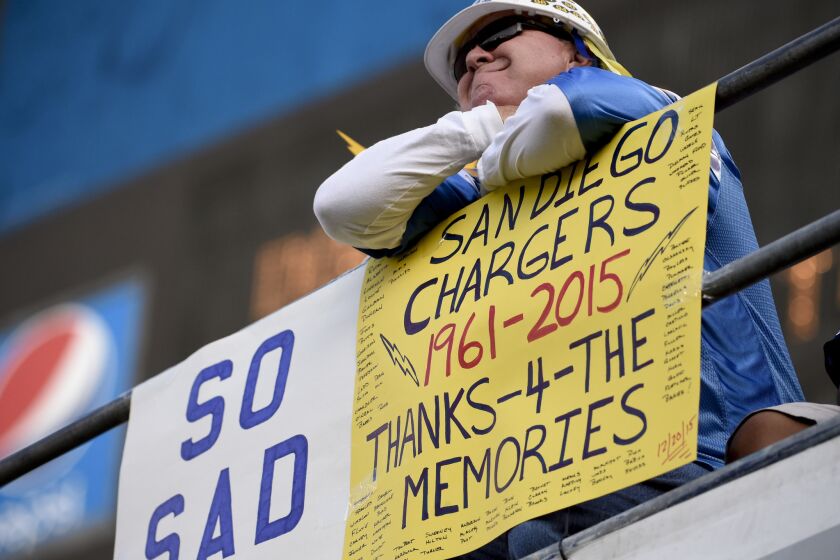 A fan holds up a sign on Dec. 20 commenting on the possible move by the San Diego Chargers.