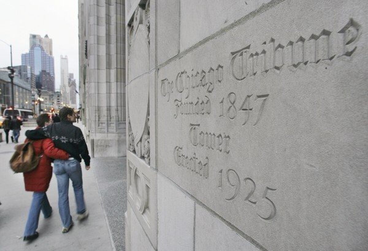 A couple walks past the front entrance to the Tribune Tower in Chicago. Tribune Co. announced Monday that it had added 19 new TV stations to its TV group.