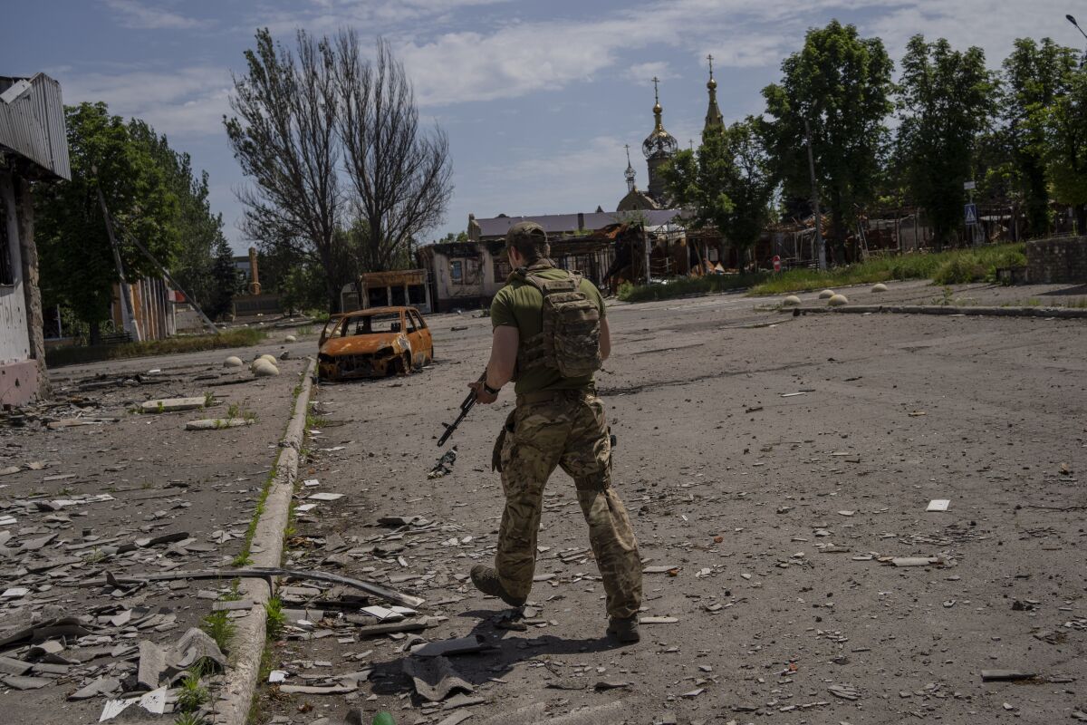 A Ukrainian serviceman patrols a village near the frontline in the Donetsk oblast region, eastern Ukraine, Thursday, June 2, 2022. (AP Photo/Bernat Armangue)