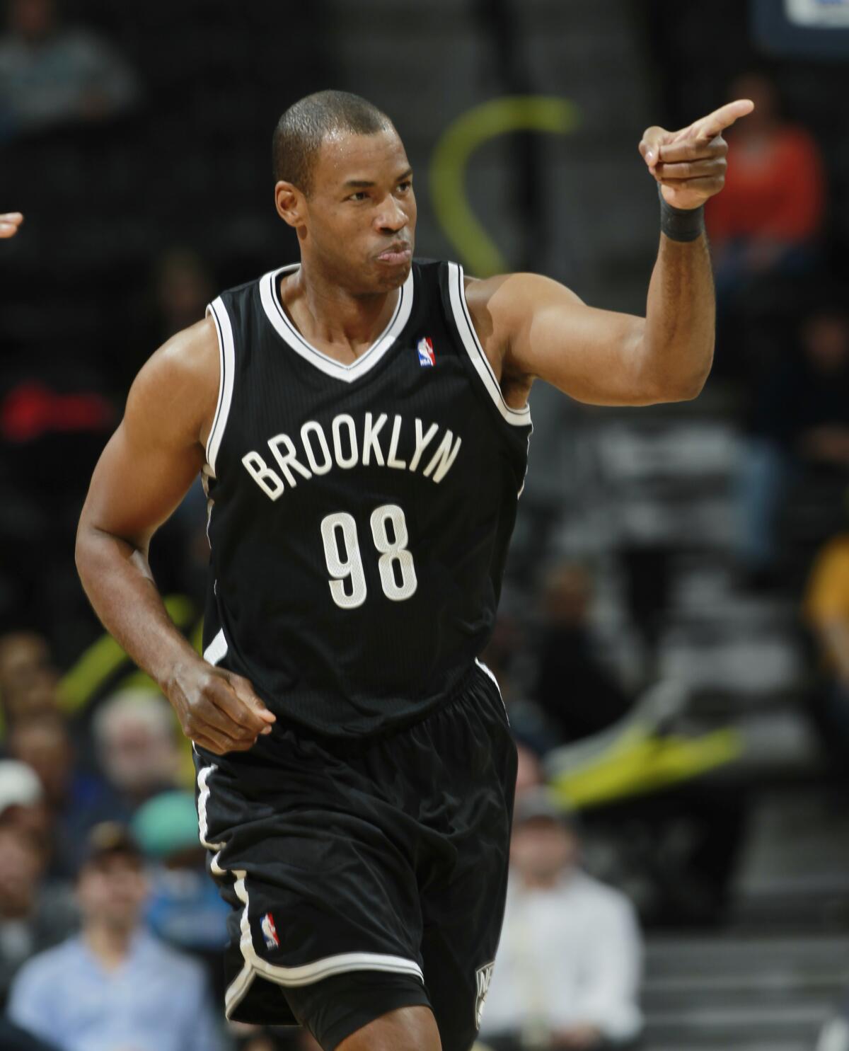 Brooklyn Nets center Jason Collins acknowledges cheers from teammates in a 2014 game.