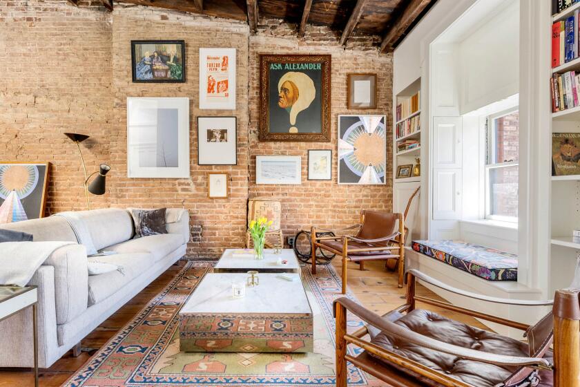 The pre-war penthouse mixes old and new with exposed brick and rustic beams broken up by five skylights.