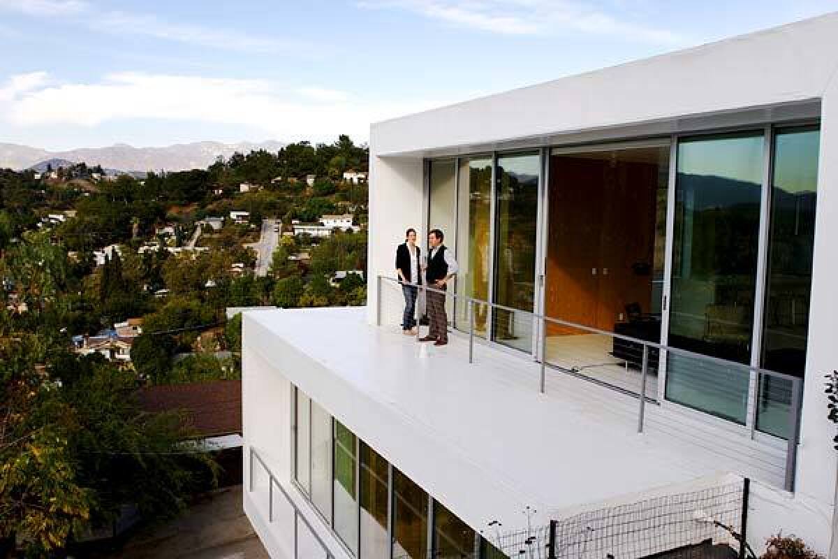 Erin Wright, director of special projects at the Los Angeles County Museum of Art, and artist Joe Sola set out to build a home in Glassell Park that had the sophistication of a gallery but was still casual and livable. They spent years developing the plan for the hillside site. "When we first went over there 10 years ago, we had a picnic on the site," architect Ravi GuneWardena said. "We identified two wonderful, but distinct views — one urban, the other natural. We wanted to highlight this contrast for those inside the house." Here, Wright and Sola stand on the top floor of the three-story house.