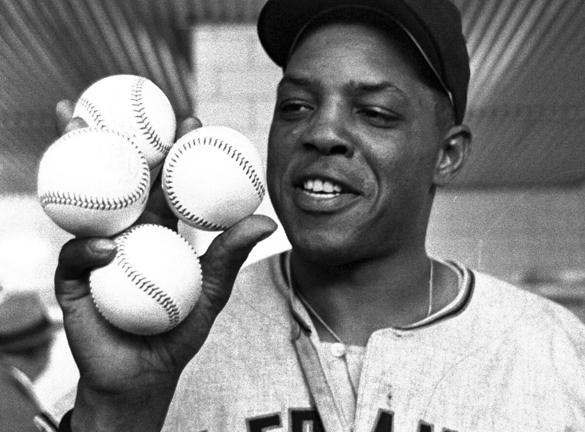 Willie Mays holds four balls, representing the four runs he hit in a single game, on April 30, 1961. 