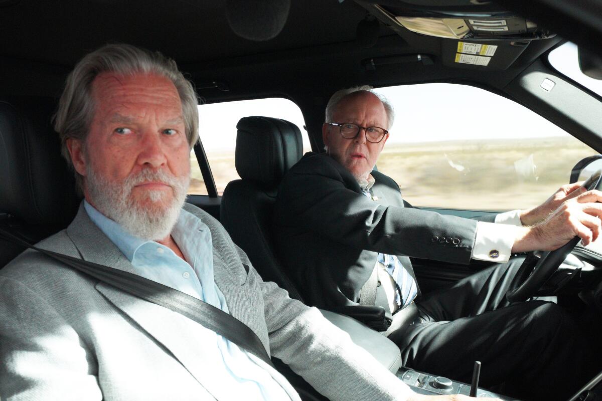 Actors Jeff Bridges and John Lithgow drive through a desert in a scene from "The Old Man."