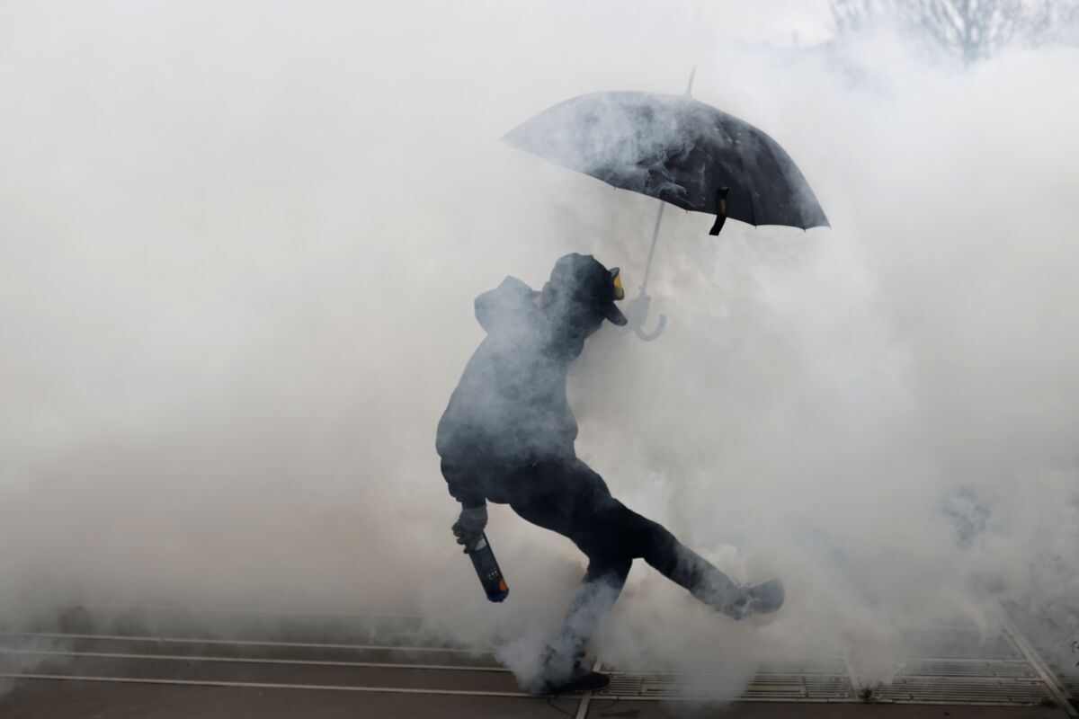 Un manifestante patea un cartucho de gas lacrimógeno arrojado por la policía durante una protesta en Nantes, oeste de Francia, el miércoles 15 de marzo de 2023, durante una protesta contra la intención del gobierno de aumentar la edad para el retiro. (AP Foto/Jeremias Gonzalez)