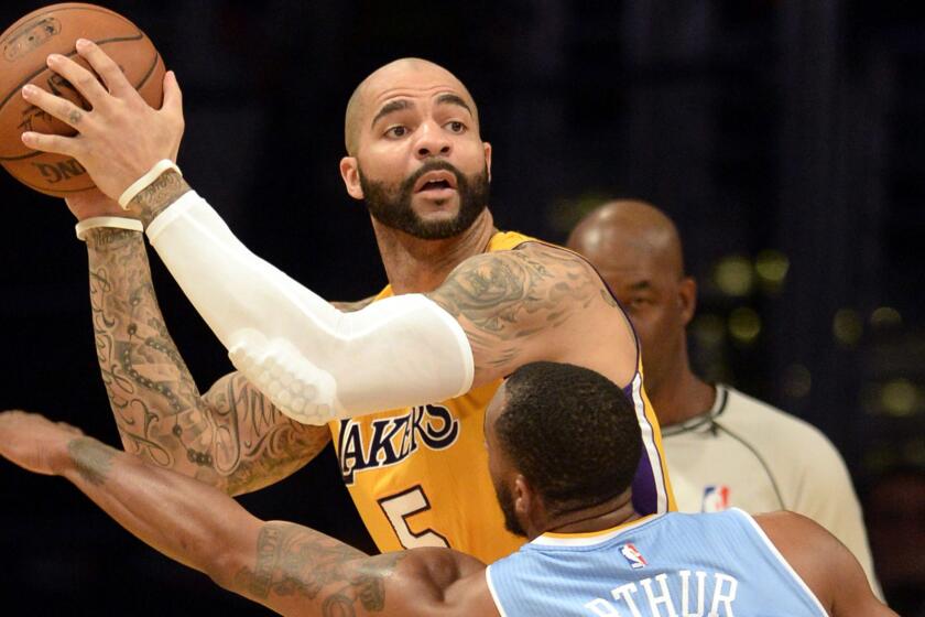 Lakers forward Carlos Boozer looks to pass over Denver Nuggets forward Darrell Arthur during a game on Feb. 10.
