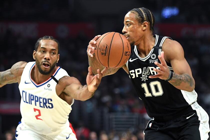 LOS ANGELES, CALIFORNIA FEBUARY 3, 2020-Clippers Kawhi Leonard knocks the ball away from Spurs DeMar DeRozen in the 2nd quarter at the Staples Center Monday. (Wally Skalij/Los Angeles Times)