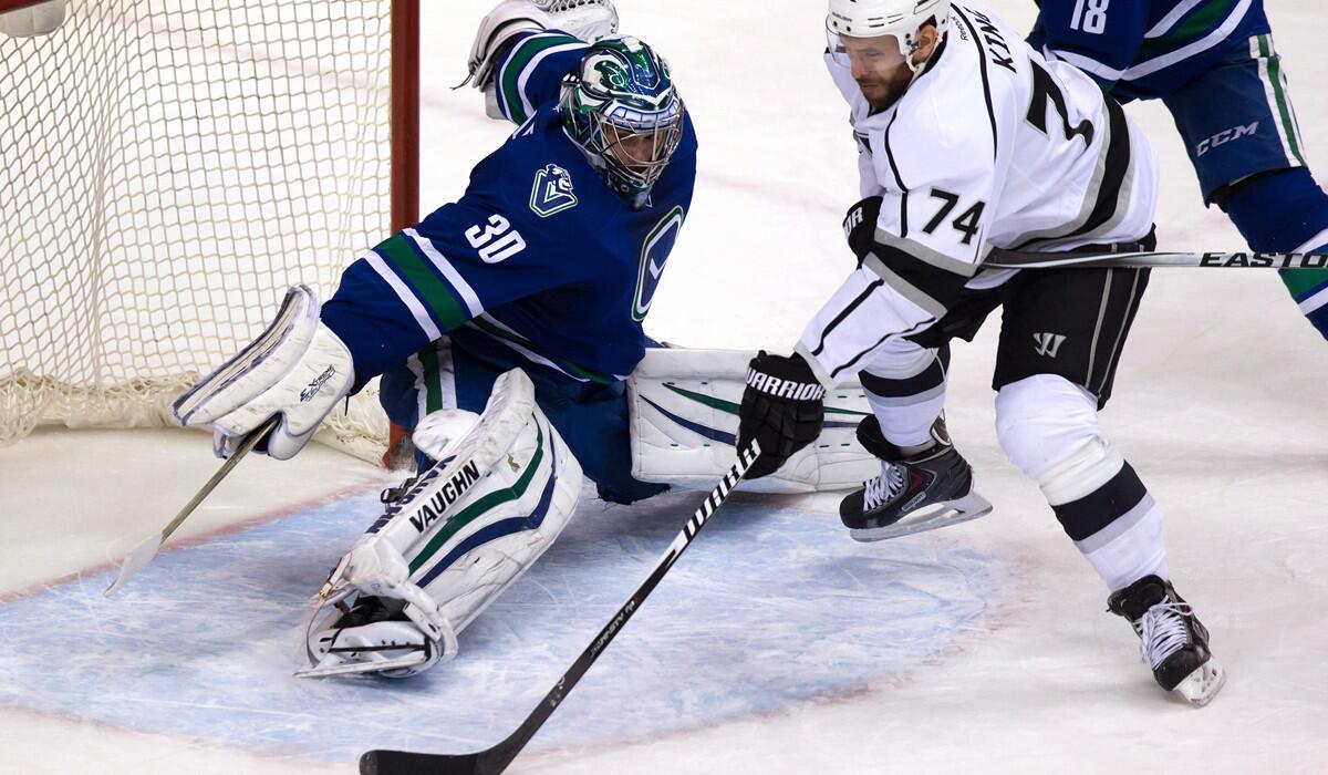 Kings forward Dwight King wraps a shot around Canucks goalie Ryan Miller in the second period in Vancouver on Jan. 1.