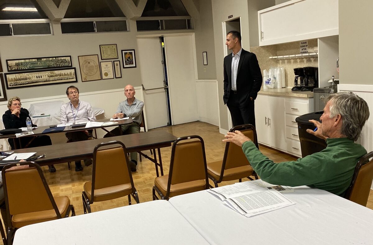 Bird Rock Community Council secretary Barbara Dunbar, president John Newsam and treasurer David Dunbar hear a complaint about the Bird Rock Maintenance Assessment District made by resident Steve Burriesci (in green) as consultant Matt Mangano (standing) looks on.