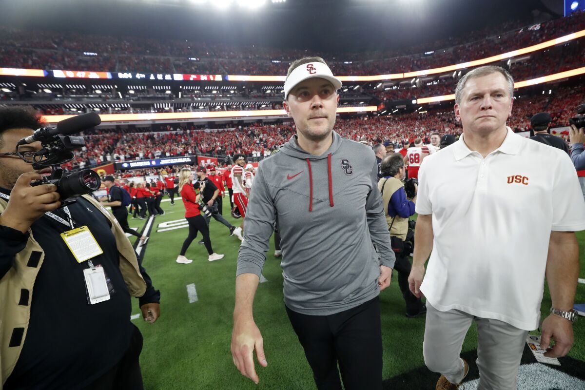 USC coach Lincoln Riley, center, leaves the field after Utah's 47-24 victory in the Pac-12 championship game Friday.