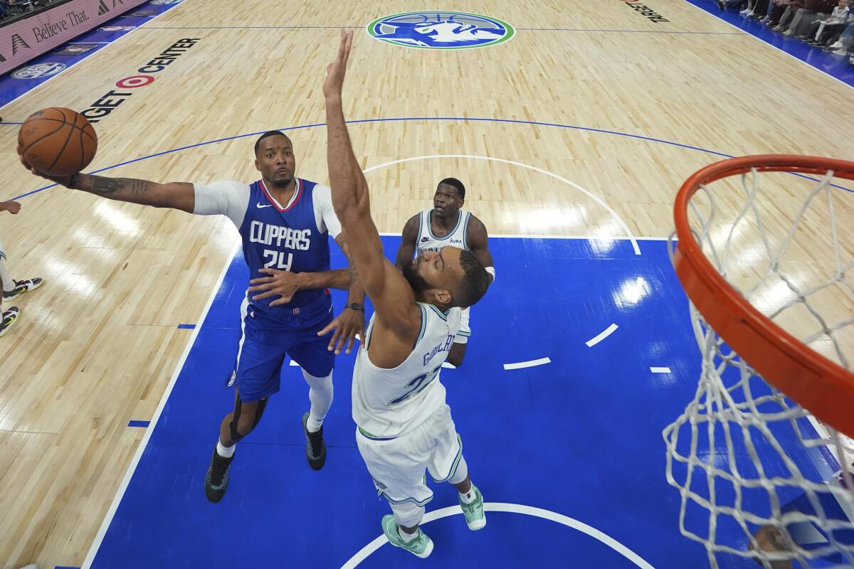 Clippers guard Norman Powell (24) elevates for a layup over Timberwolves 7-foot-1 center Rudy Gobert.