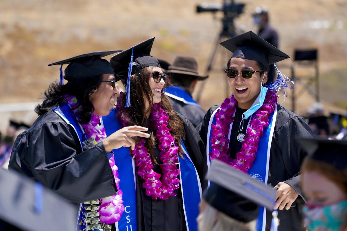 Cal State San Marcos graduates catch up at Saturday's in-person commencement ceremony on campus.
