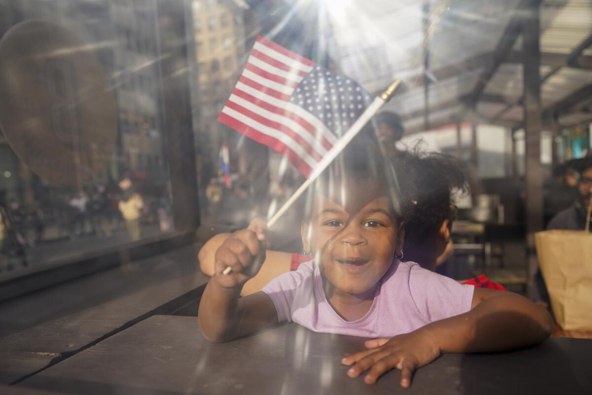 A young spectator cheers as participants march up Fifth Avenue during the 102nd annual Veterans Day Parade, Thursday, Nov. 11, 2021, in New York. (AP Photo/Mary Altaffer)