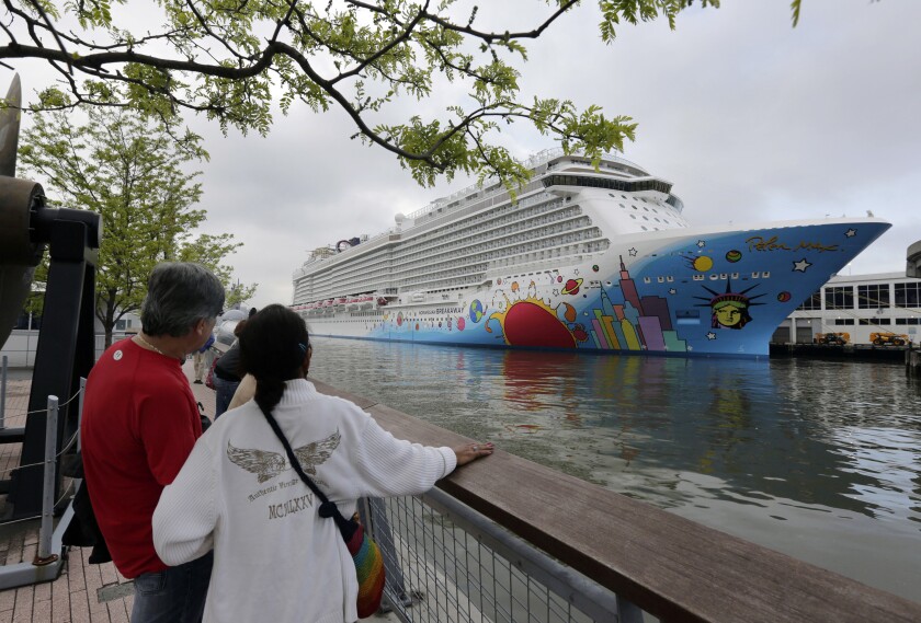 FILE - People pause to look at Norwegian Cruise Line's ship, Norwegian Breakaway, on the Hudson River, in New York, on May 8, 2013. A cruise ship that carried at least 17 passengers and crew members with COVID-19 breakthrough infections has left New Orleans with new passengers. The Louisiana Department of Health said Monday, Dec. 6, 2021 that nine crew members and eight passengers were infected when the Norwegian Breakaway docked in New Orleans. (AP Photo/Richard Drew, File)