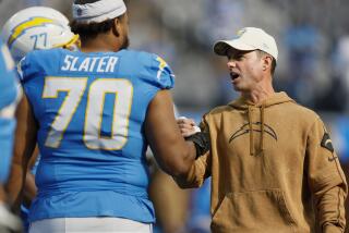 Chargers coach Brandon Staley greets offensive lineman Rashawn Slater.