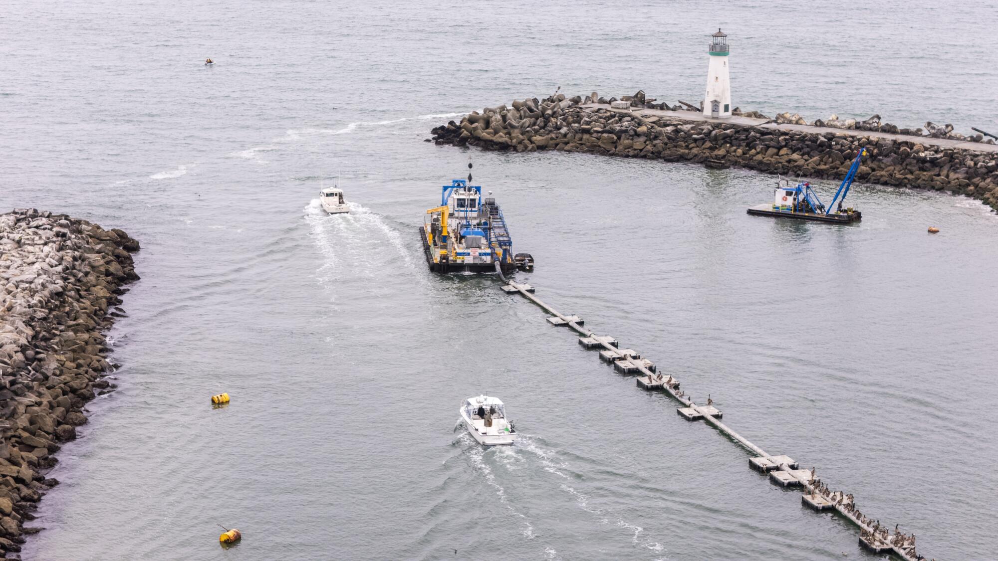 Fishing ships are directed towards an opening between the breaks, one of what a lighthouse has