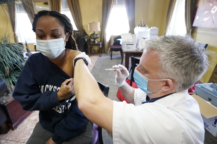 FILE - In this Jan. 12, 2021, file photo, Walgreens pharmacist Chris McLaurin prepares to vaccinate Lakandra McNealy, a Harmony Court Assisted Living employee, with the Pfizer-BioNTech COVID-19 vaccine in Jackson, Miss. The coronavirus vaccines have been rolled out unevenly across the U.S., but some states in the Deep South have had particularly dismal inoculation rates. (AP Photo/Rogelio V. Solis, File)