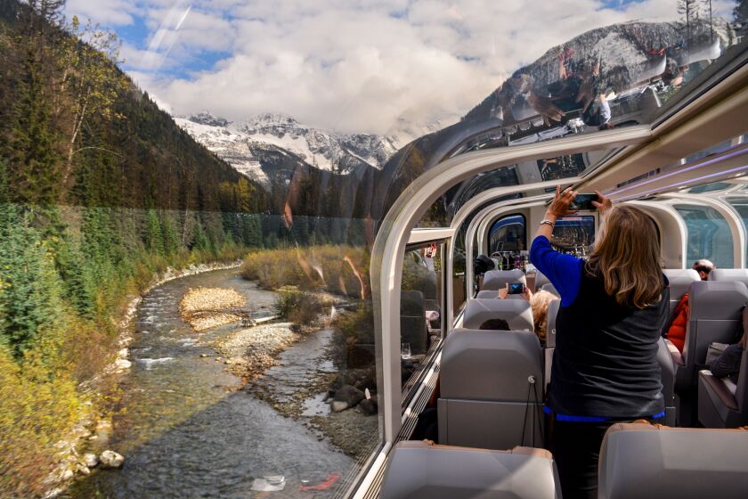 Passengers aboard the Rocky Mountaineer train enjoy one of the dome cars, giving them spectaclar views of the Canadian Rockies as they climb toward Banff in Alberta, Canada.