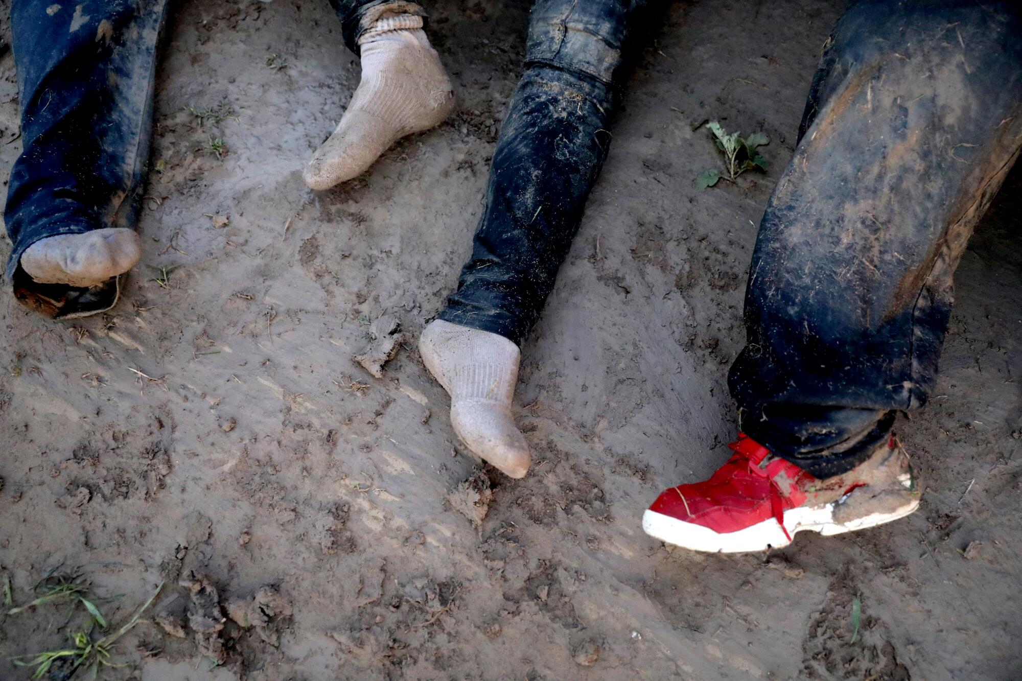 Mud caked migrants collapse after crossing the U.S.-Mexico border in McAllen, Texas.