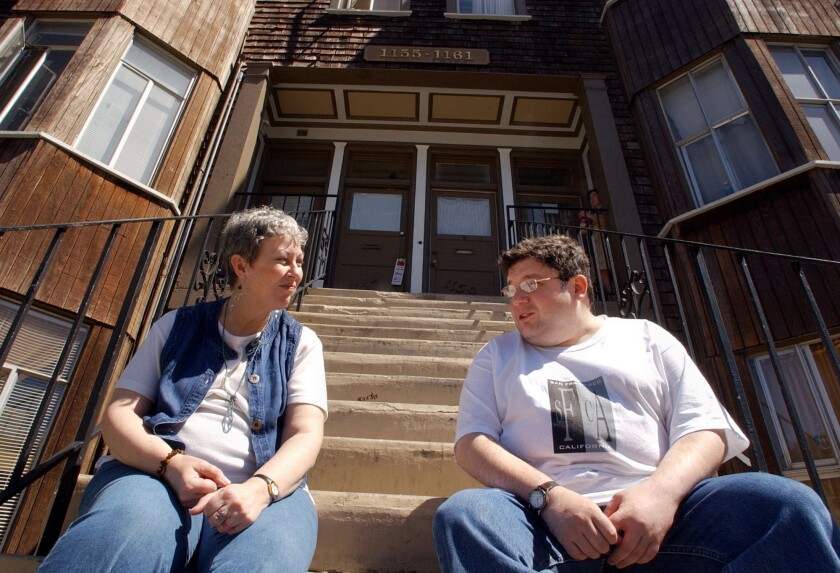 Carrie McGinniss, left, and housemate Michael Allen, right, chat outside their apartment in San Francisco.