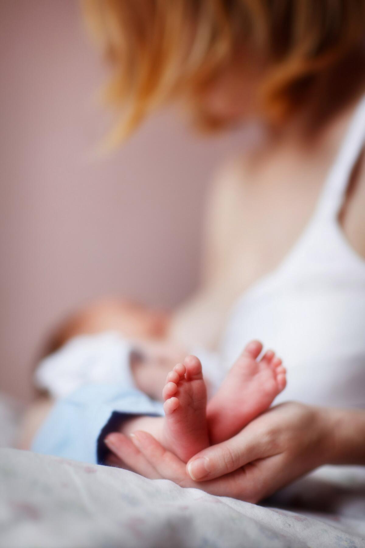 A mother breastfeeds her newborn.