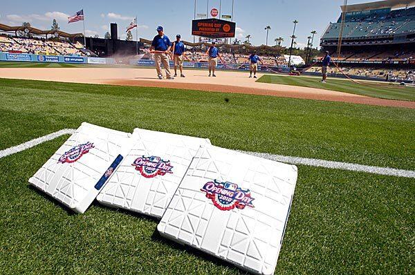 Members of the grounds crew prepare the field for the Dodgers' home opener against the Arizona Diamondback on Tuesday.