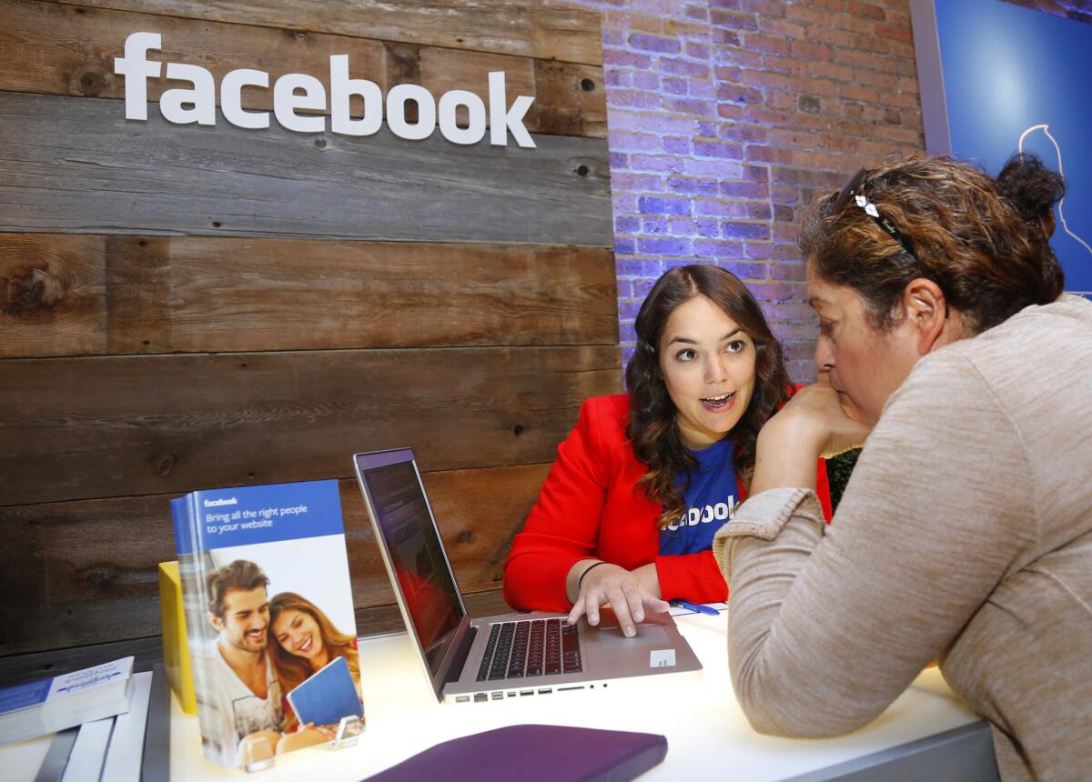 Facebook employee Catherine Doyle engages with a small-business owner at an event in Chicago. The company has been holding similar events across the country this summer.