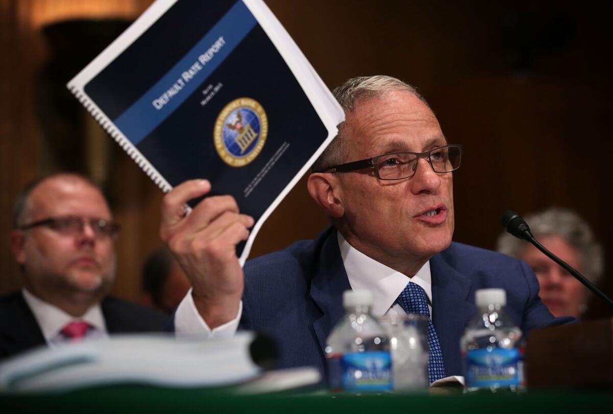 Fred Hochberg, president of the federal Export-Import Bank, holds up a copy of the bank's default rate report as he testifies before a Senate committee in June 2015.