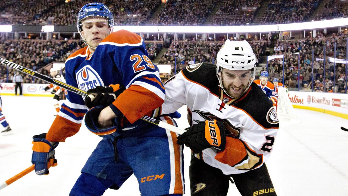 Edmonton Oilers forward Leon Draisaitl, left, battles with Ducks forward Kyle Palmieri in the first period of the Ducks' 4-2 win Friday.