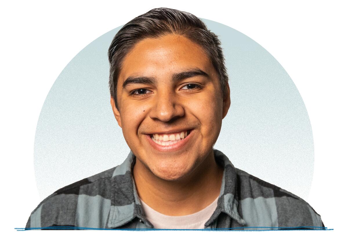 A young man wearing a black and gray checkered shirt smiling for a portrait.