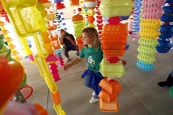A child makes her way through "HappyHappy," an outdoor installation at the Los Angeles County Museum of Art. Artist Choi Jeong-Hwa made it out of hundreds of plastic bins, tubs and bowls as part of "Your Bright Future: 12 Contemporary Artists From Korea."