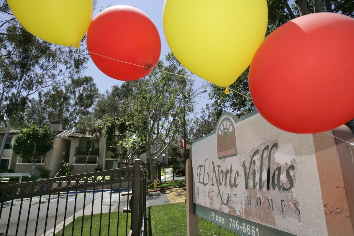 Helium balloons blow in the wind in front of the El Norte Villas apartment complex in Escondido.