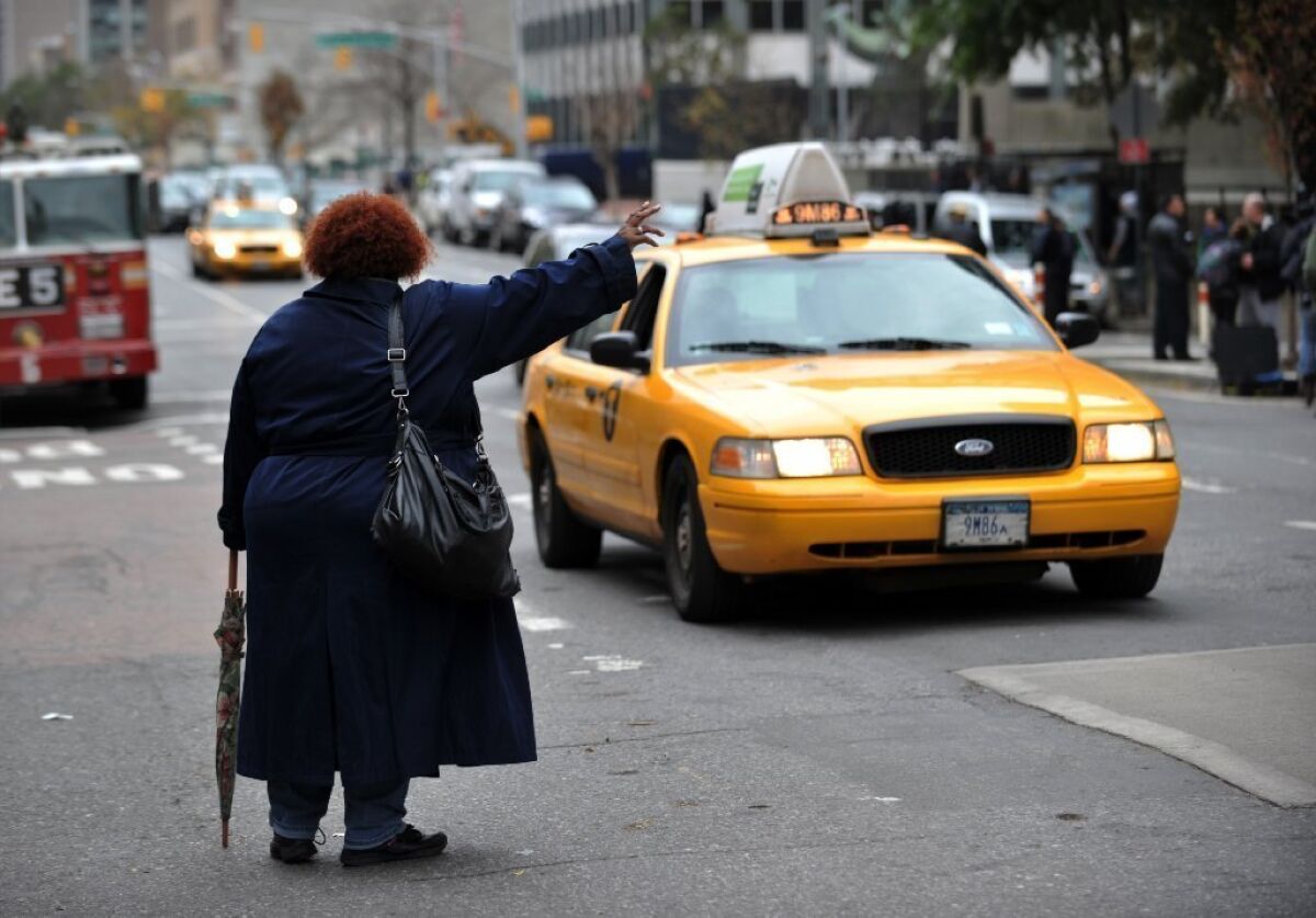 A woman tries to hail a taxi on First Avenue in New York.