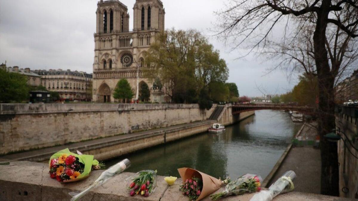 Flowers are left on a bridge in Paris near Notre Dame after a massive fire destroyed the cathedral's roof on April 15.