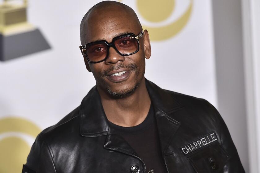 FILE - In this Jan. 28, 2018 file photo, Dave Chappelle poses in the press room with the best comedy album award for "The Age of Spin" and "Deep in the Heart of Texas" at the 60th annual Grammy Awards at Madison Square Garden in New York. Chappelle, Sandra Bullock, Christopher Walken, Rita Moreno and Helen Mirren are among the latest slate of stars set to appear on the 90th Academy Awards. Oscar telecast producers revealed another round of celebrity presenters on Tuesday, Feb. 17, 2018, which also includes Jane Fonda, Matthew McConaughey, Lupita Nyongâo, Nicole Kidman, Jodie Foster, Ashley Judd and Eugenio Derbez.(Photo by Charles Sykes/Invision/AP, File)