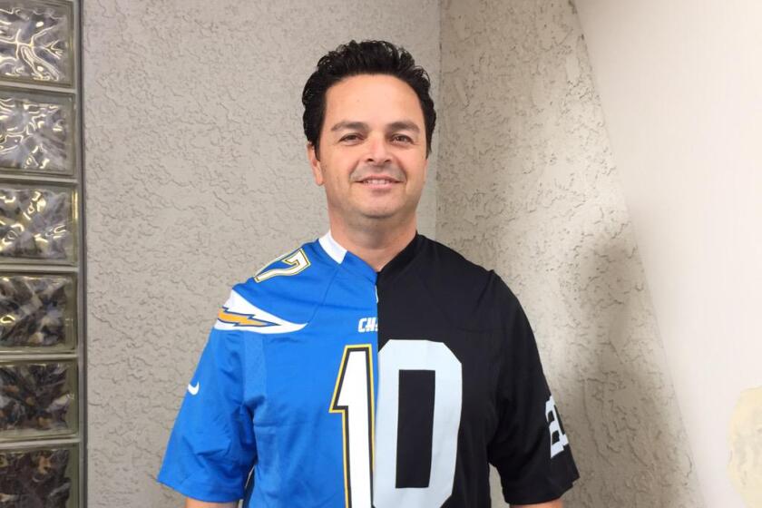 Albert Robles, then a Carson councilman, wears a split Chargers-Raiders shirt to a news conference Feb. 20, 2015.