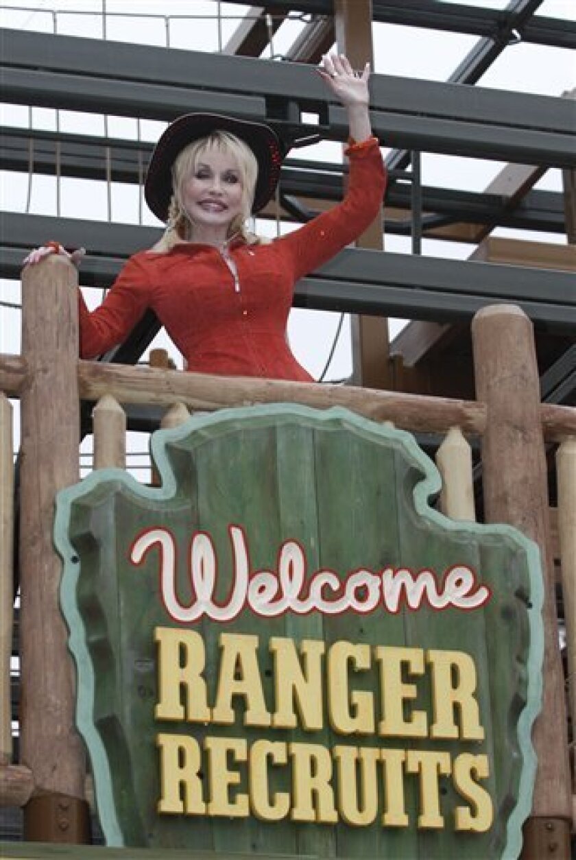 Dolly Parton waves to guests at her latest attraction, Adventure Mountain, during the 25th anniversary celebration of the Dollywood Theme Park, Friday, March 26, 2010 in Pigeon Forge, Tenn. (AP Photo/Wade Payne)