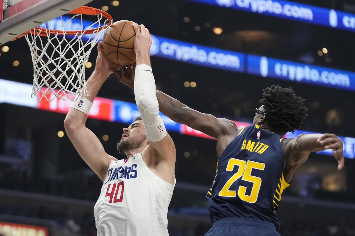  Clippers center Ivica Zubac grabs a rebound away from Indiana Pacers forward Jalen Smith. 