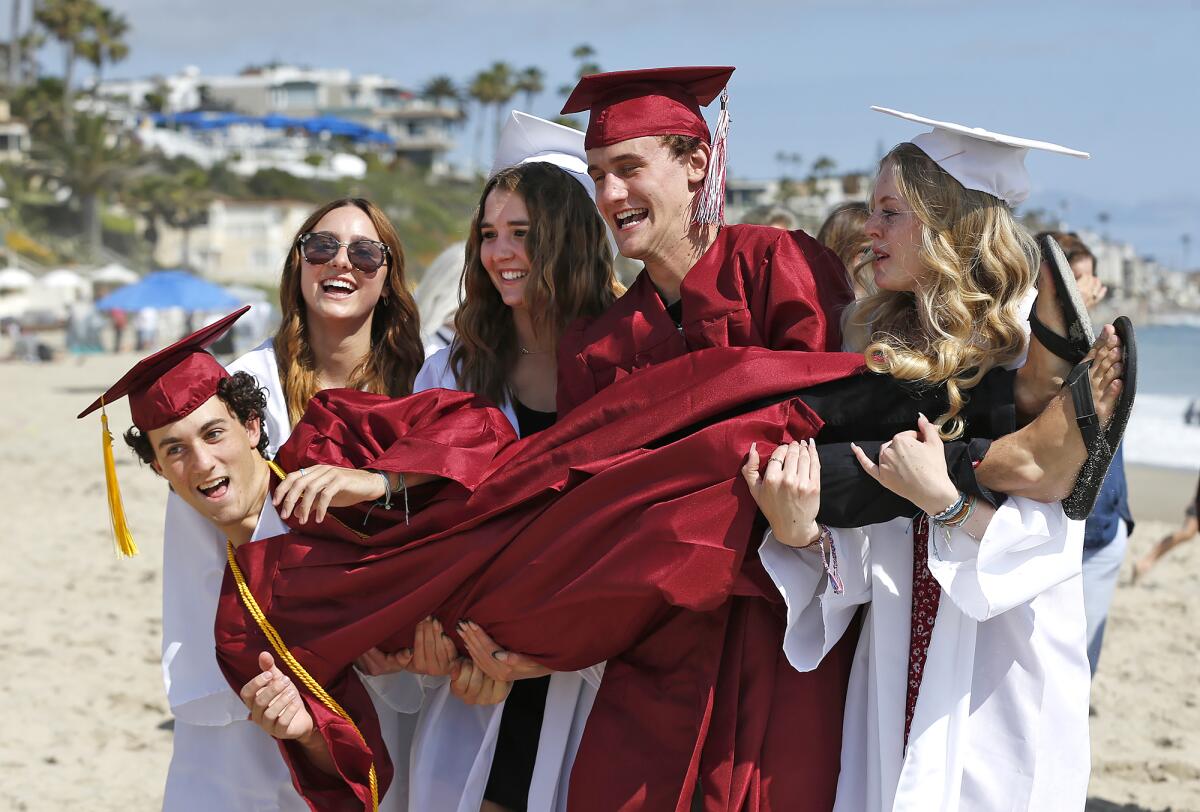 Laguna Beach High seniors carry Gavin Zaengle up the beach on Wednesday afternoon in downtown Laguna Beach.