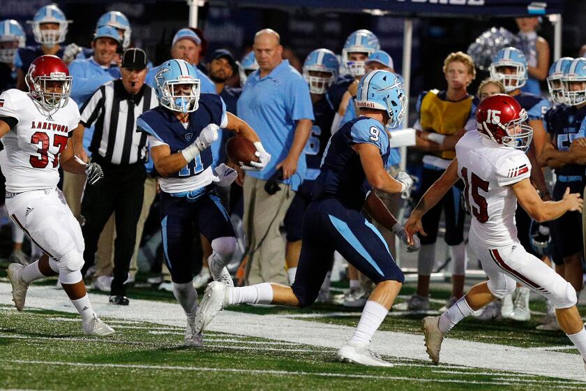 Corona del Mar's Bradley Schlom cuts away from the sidelines, taking advantage of a block from teammate Carter Duss to run for a touchdown off of a Lakewood punt return in a non-league football game at Newport Harbor High School on Friday, September 13, 2019.